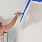 professionnel de l'entreprise ECO Peintre qui peint un mur en bleu